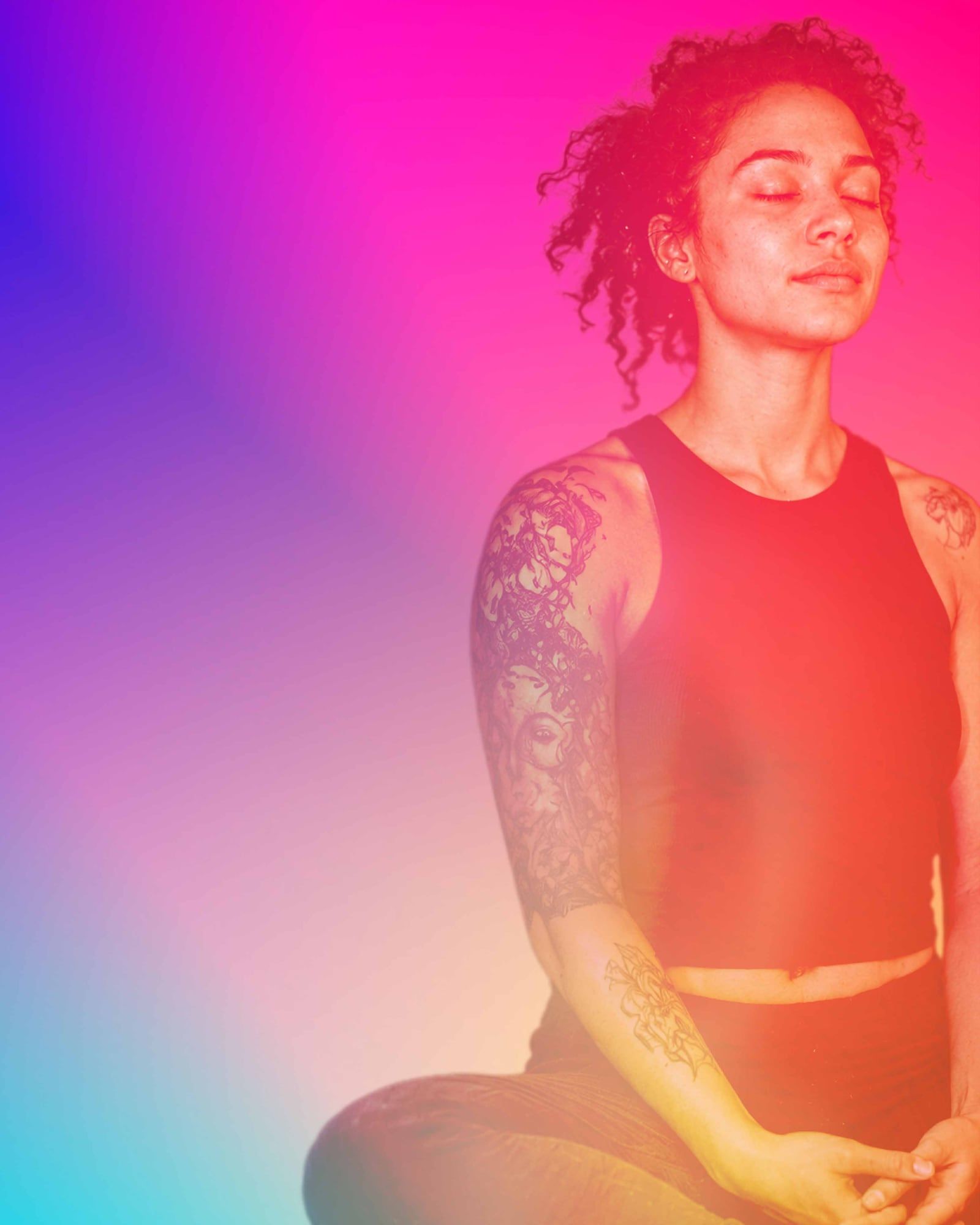 A woman sitting cross-legged with her eyes closed, meditating